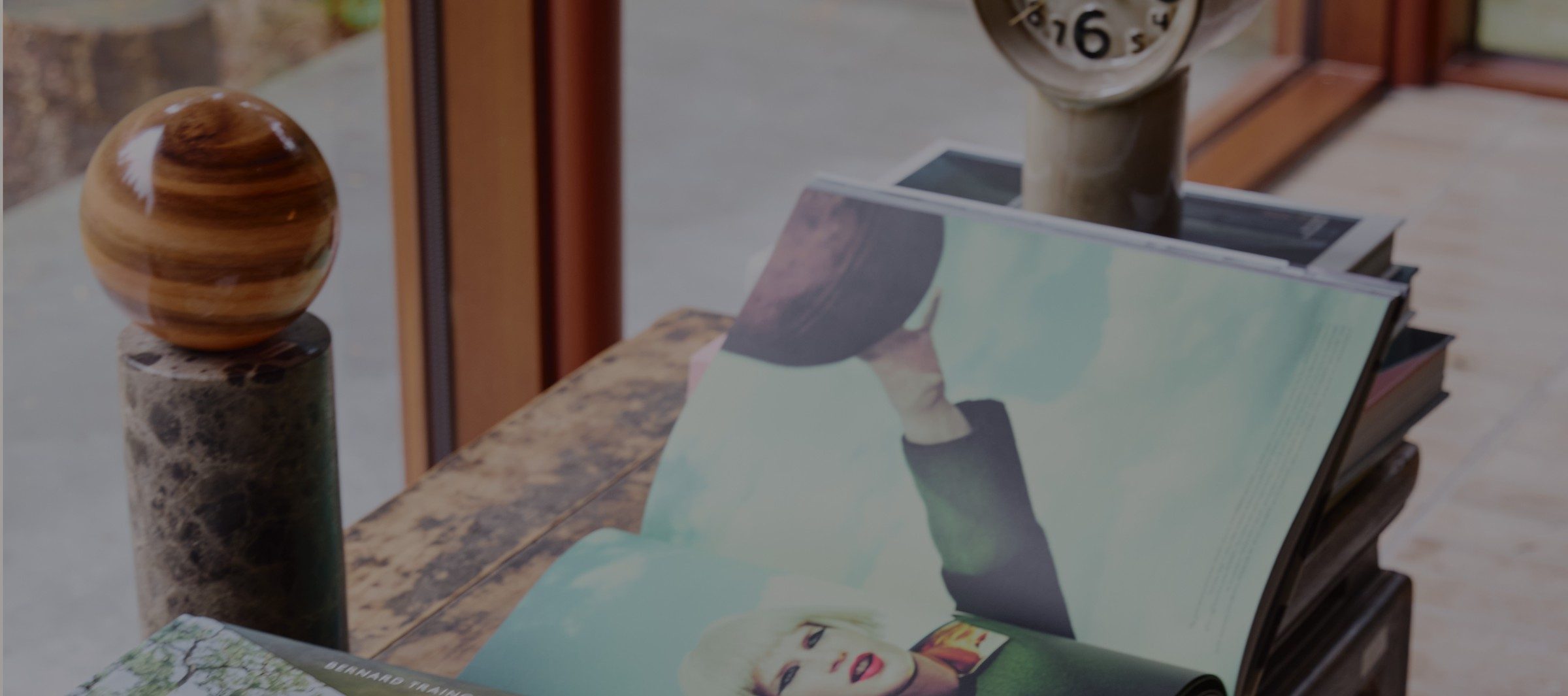 Still life of vintage magazines and a hand-turned wooden sphere on a Meyowi console table