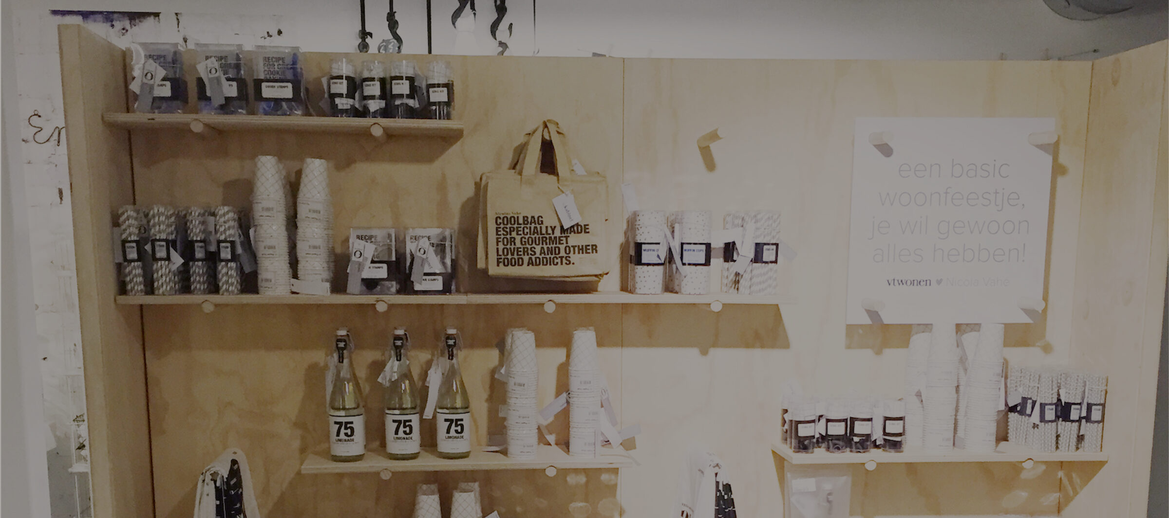 Warme houten schappen vol vtwonen woonaccessoires, servies en decoratie in de concept store